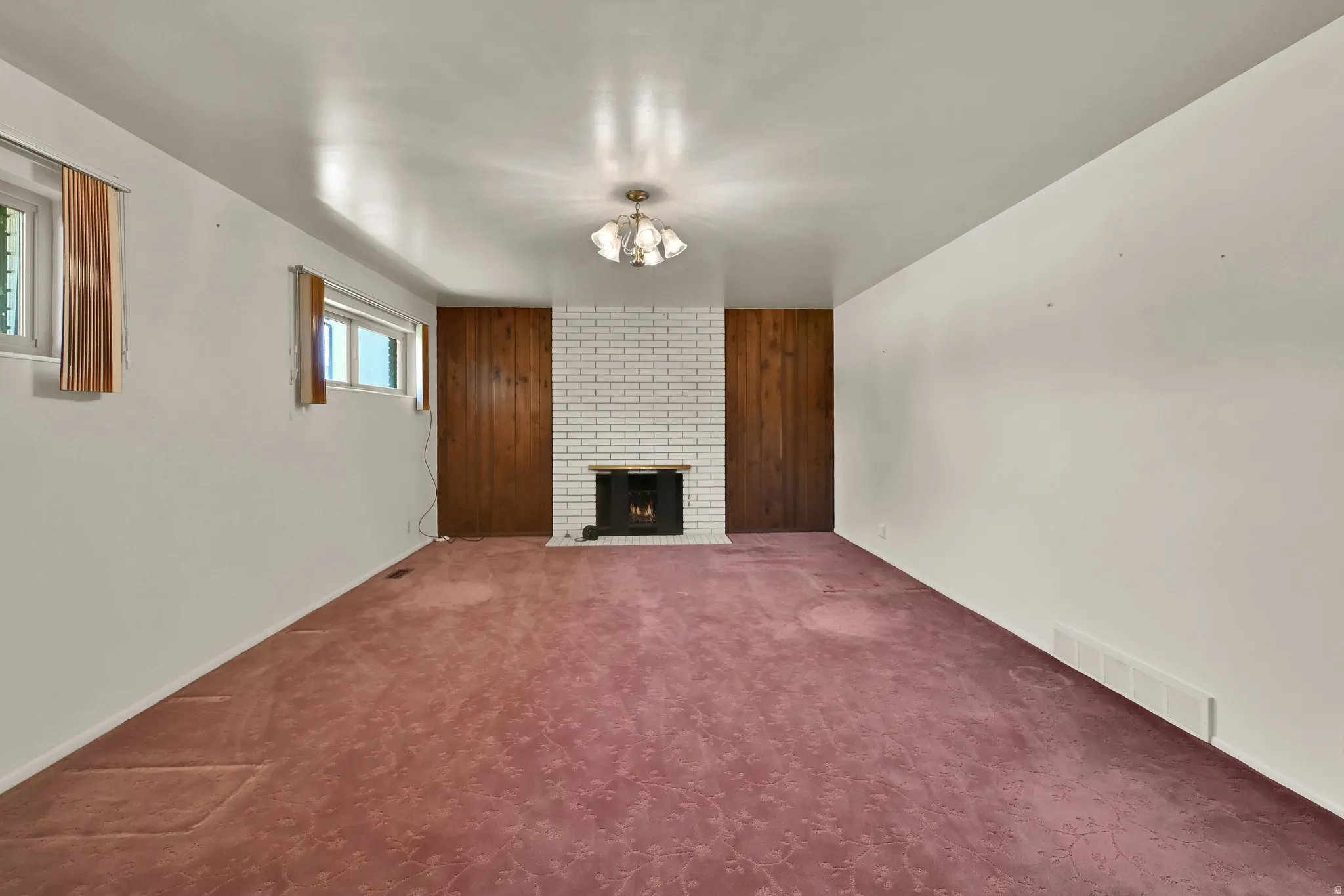 White brick fireplace with dark wood paneling accents