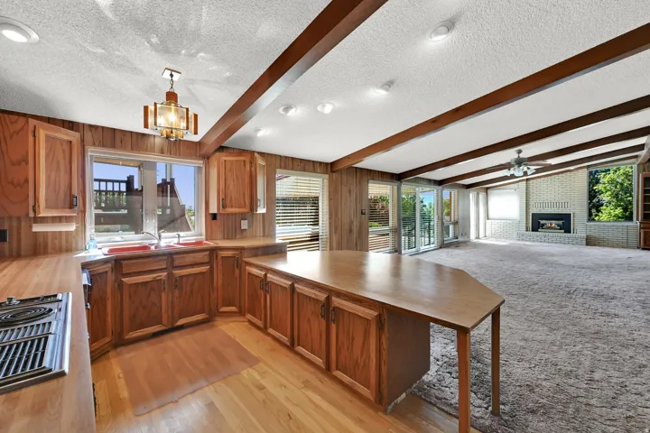 Kitchen with wood cabinetry, wood-finish flooring, and a built-in range