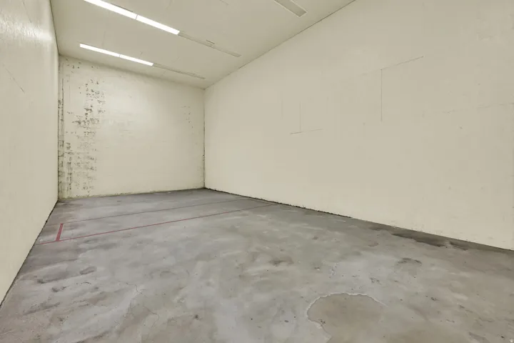 Indoor court space with concrete flooring and overhead fluorescent lighting
