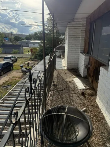 Exterior balcony with wrought iron railing and a gravel surface