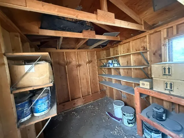 Wood-paneled interior with exposed rafters and integrated shelving