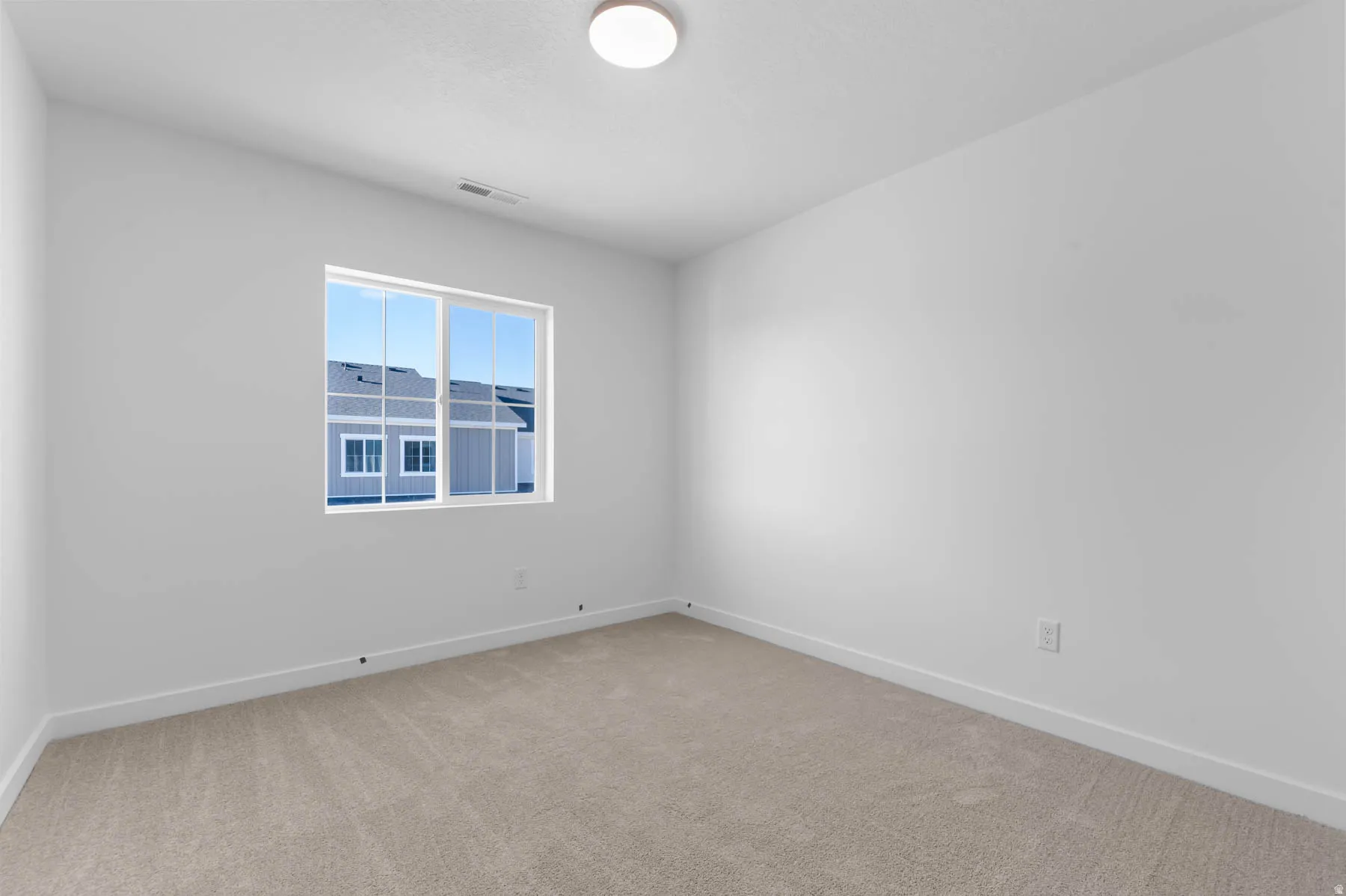 Neutral color palette, window with white trim, recessed lighting, light-toned carpet flooring, white painted walls
