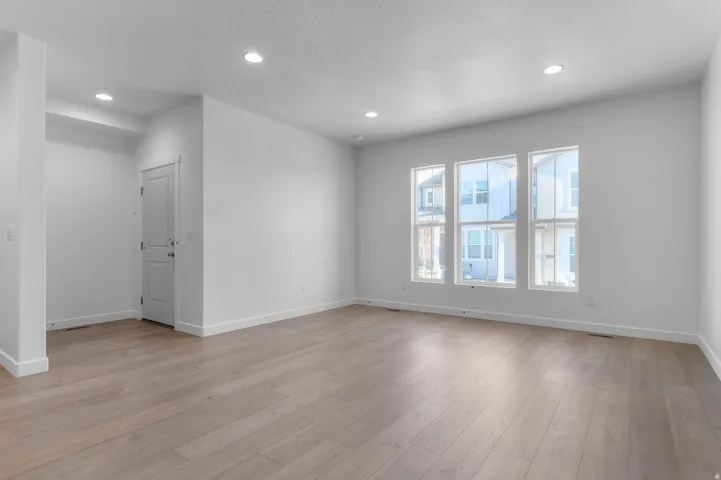 Wood-finish flooring, recessed lighting, and multiple large windows