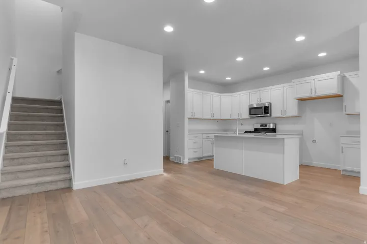 Contemporary kitchen featuring white cabinetry, stainless steel appliances, a center island, and recessed lighting
