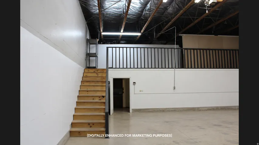 Wood-finish staircase leading to a mezzanine level with black metal railings