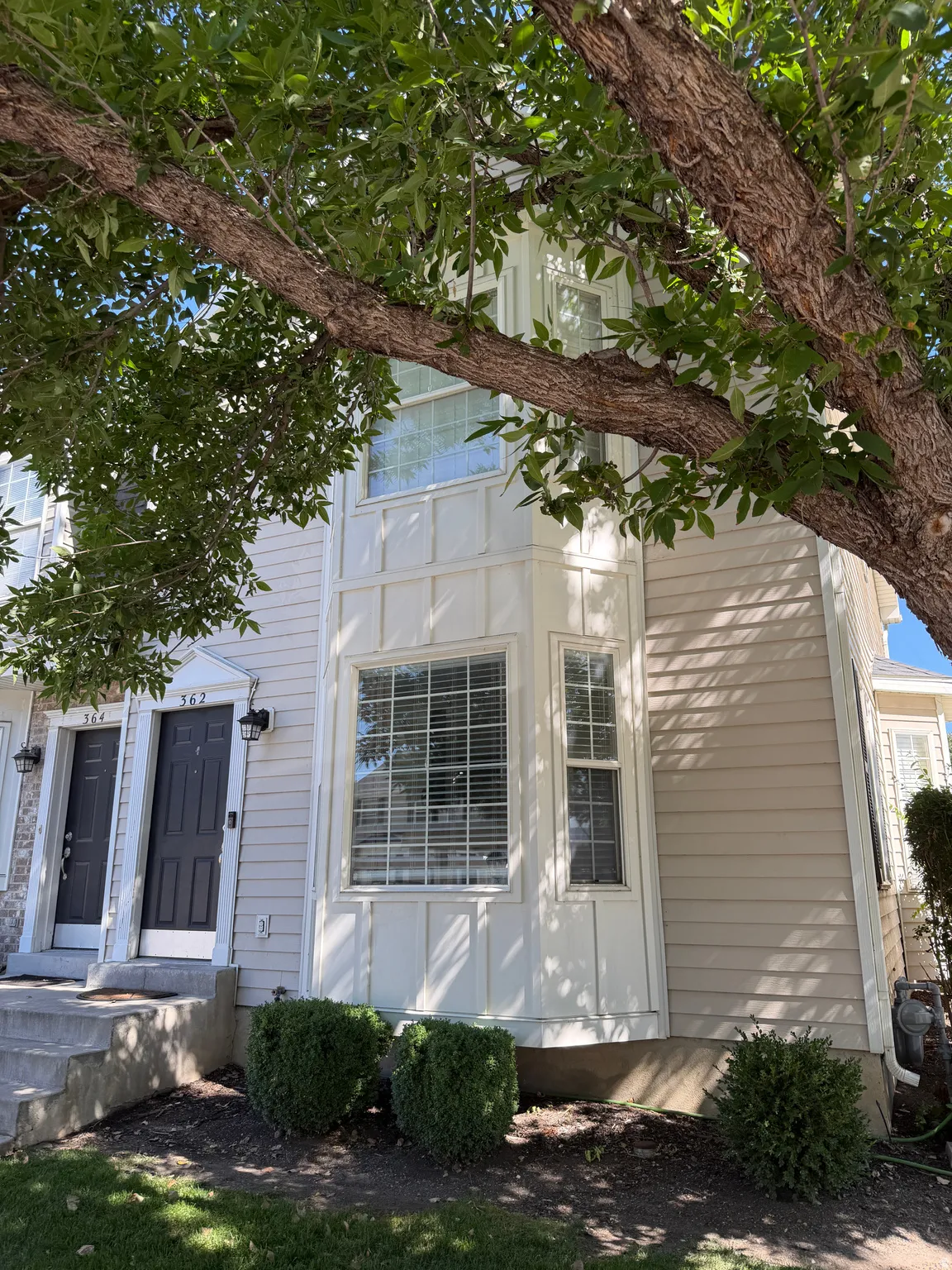 Facade featuring light-toned horizontal siding and white architectural trim