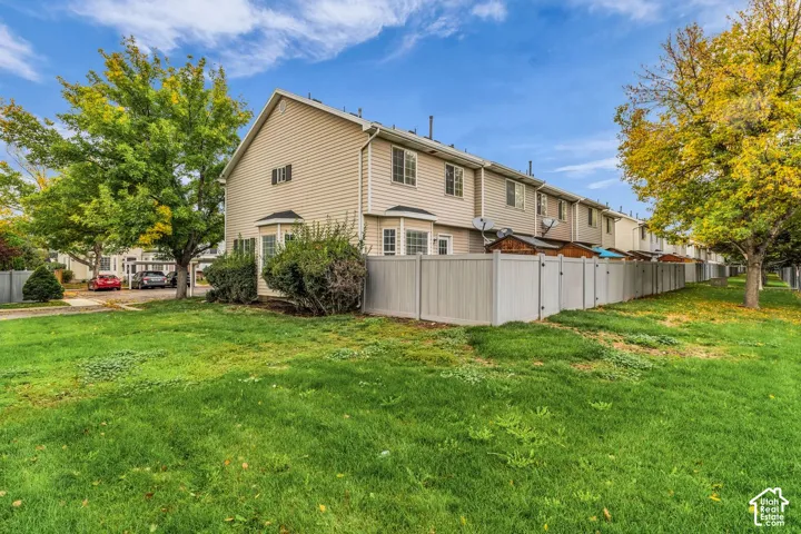 Two-story exterior with horizontal siding, bay windows, and a privacy fence