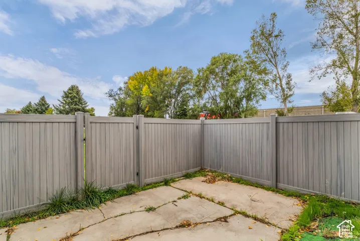 Concrete patio area enclosed by full-height gray vinyl fencing