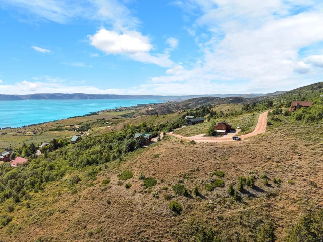 Expansive hillside property featuring a lake backdrop and surrounding mountain ranges