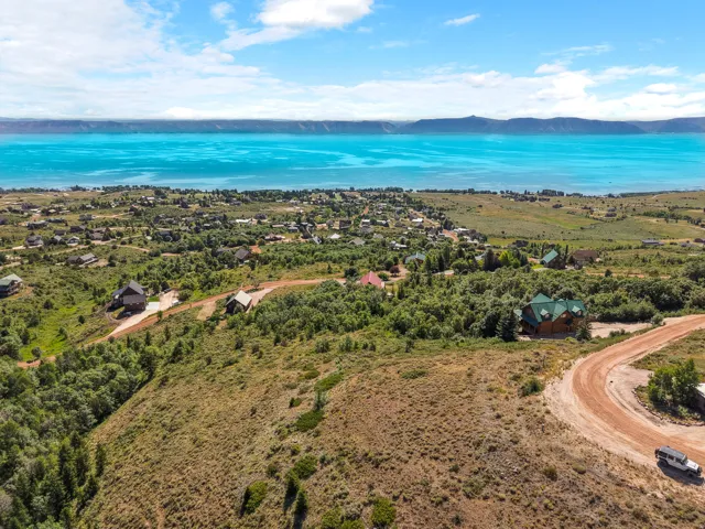 Expansive terrain featuring a distant lake and mountainous horizon