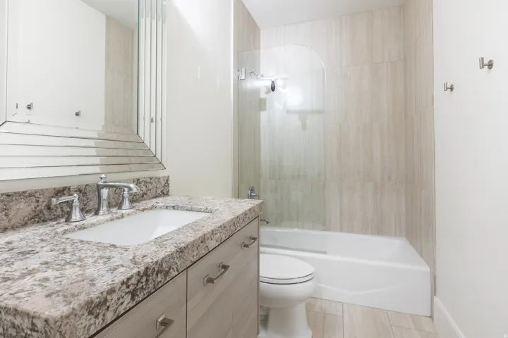 Vanity with a polished stone countertop, undermount sink, and chrome faucet