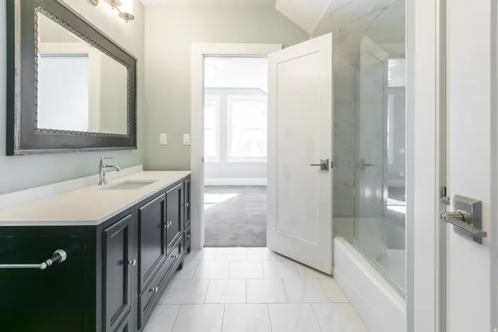 Spacious vanity with stone countertop, undermount sink, and chrome faucet