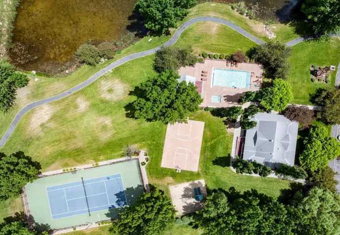 Expansive recreational grounds featuring a tennis court, basketball court, swimming pool, and dedicated walking paths