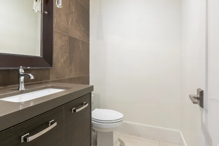 Vanity with a rectangular undermount sink, chrome faucet, and dark wood-finish cabinetry