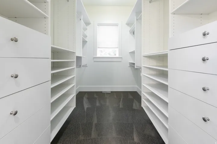 Custom closet system featuring multiple drawers, adjustable shelving, and hanging rods
