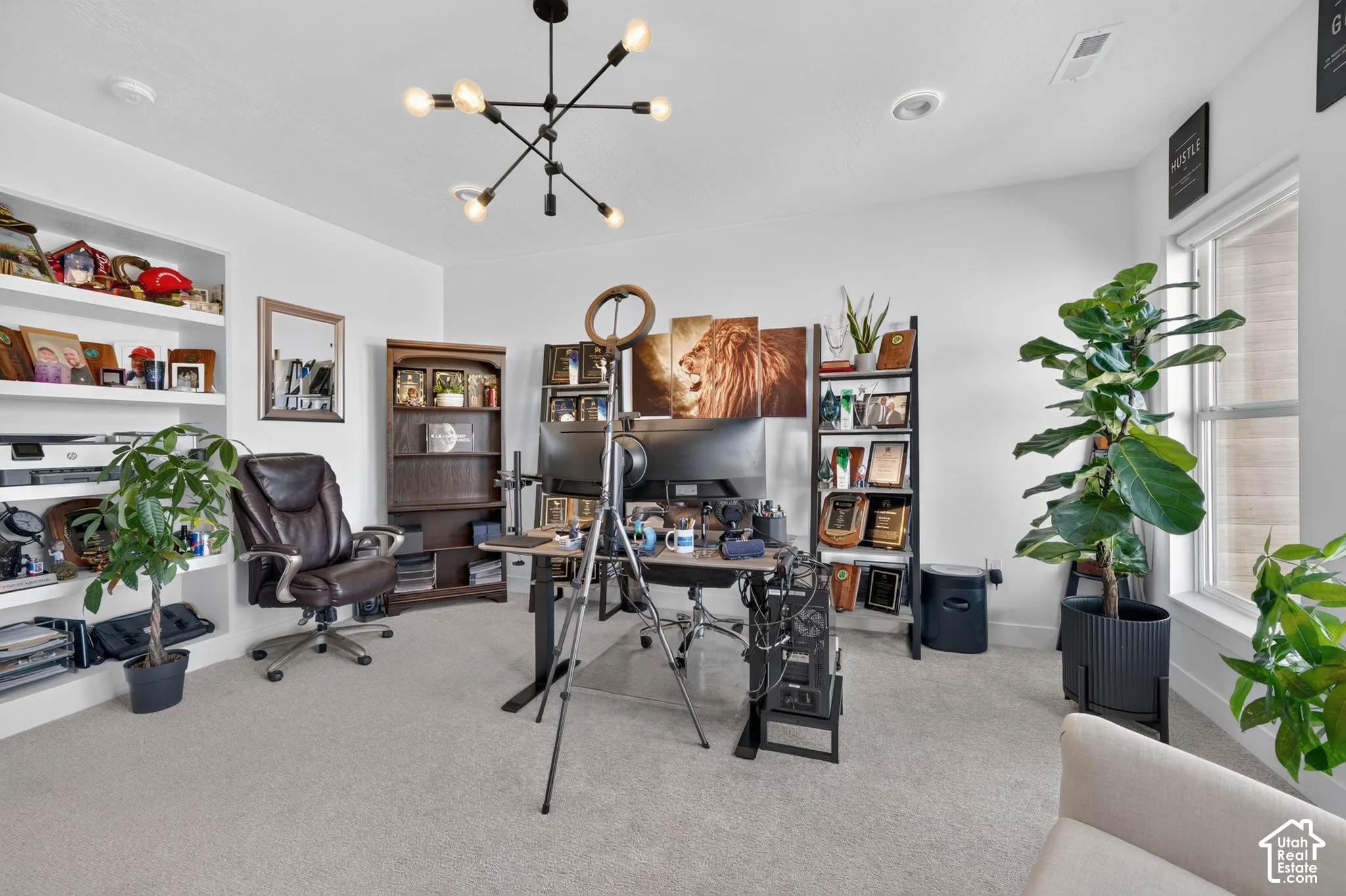 Recessed lighting, built-in shelving, and a modern chandelier
