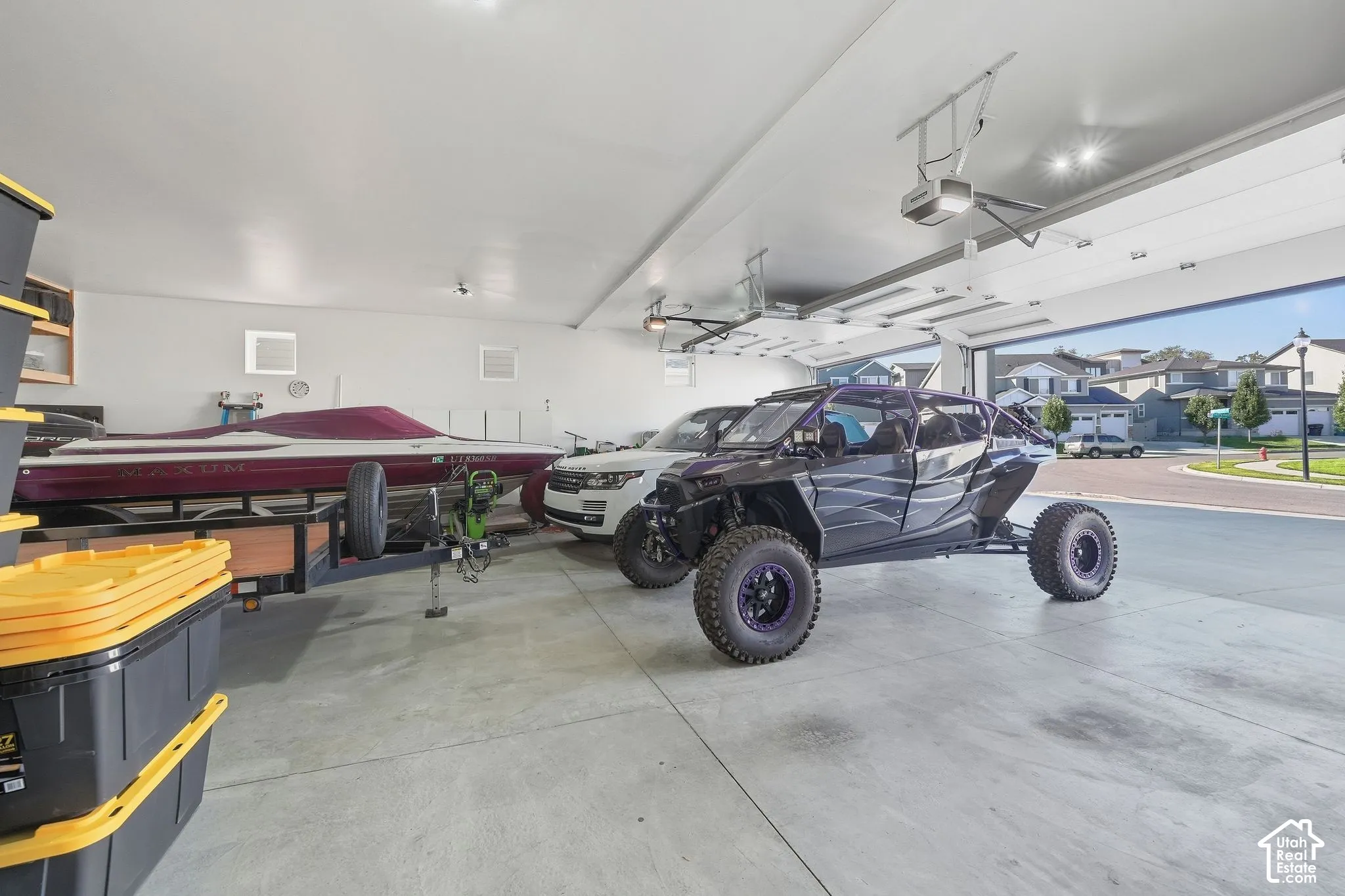 Spacious garage with multiple garage doors, concrete flooring, and recessed lighting