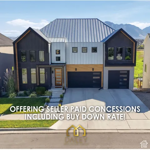 Contemporary two-story exterior featuring vertical metal siding, a standing seam metal roof, multi-car garage with glass-paneled doors, wood-finish accents, and mountain scenery