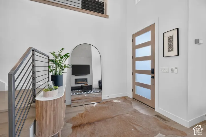 Two-story entry with a wood-finish door featuring frosted glass panels