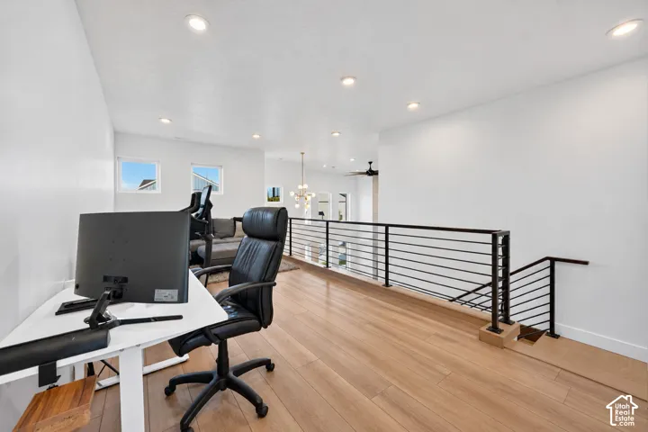 Wood-finish flooring, recessed lighting, and a contemporary black metal stair railing