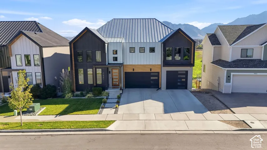 Modern architectural design featuring varied siding materials and a metal roof