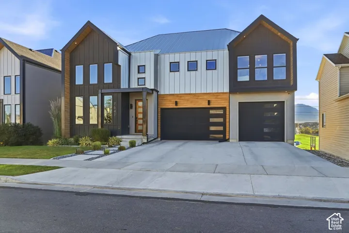 Modern exterior featuring black vertical siding, white vertical siding, wood-finish paneling, and a metal roof