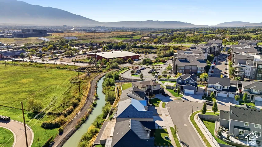 Community featuring a meandering waterway, mature trees, and paved streets