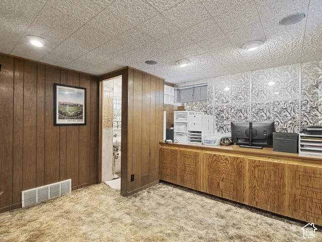 Recessed lighting, wood paneling, built-in wood cabinetry, patterned wall covering, window with privacy blind