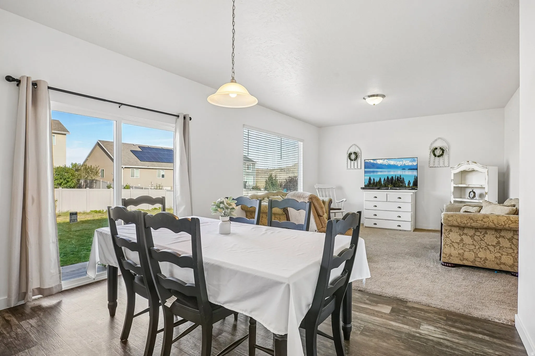 Dining area with wood-finish flooring and a pendant light fixture