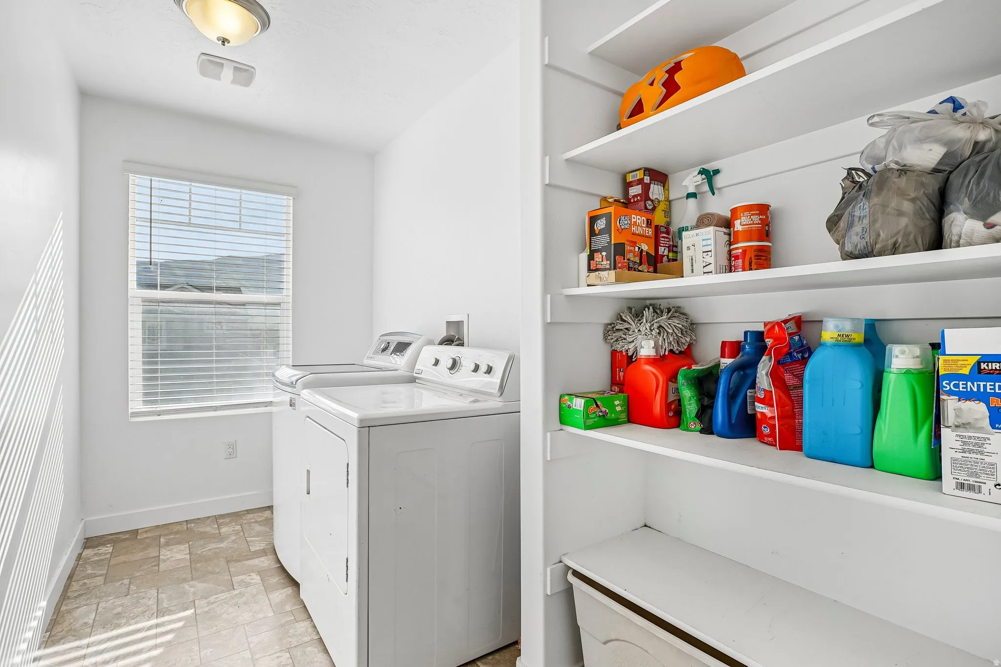 Laundry area featuring a window, overhead lighting, and built-in shelving