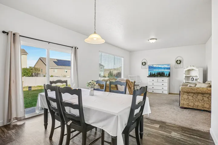 Dining area with wood-finish flooring and a pendant light fixture
