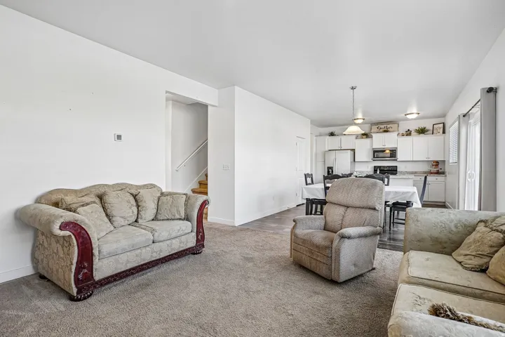 Open-concept living area with carpet flooring and white walls