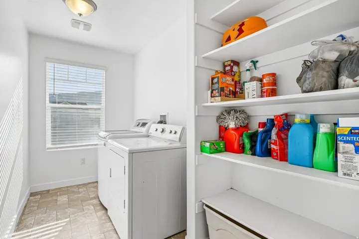 Laundry area featuring a window, overhead lighting, and built-in shelving