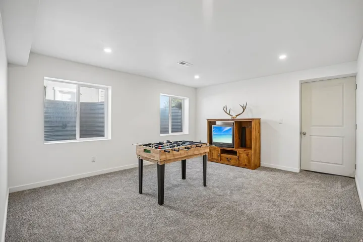 Carpeted room with recessed lighting and two windows