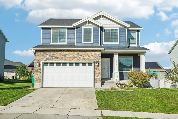 Two-story residence featuring a stone and siding exterior, an attached two-car garage, and a concrete driveway