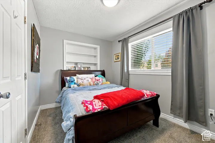 Built-in shelving, flush-mount ceiling light, window with blinds, and paneled interior door