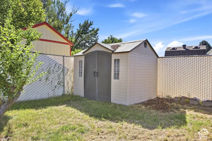 Exterior shed with a gabled roof, panel siding, and double doors