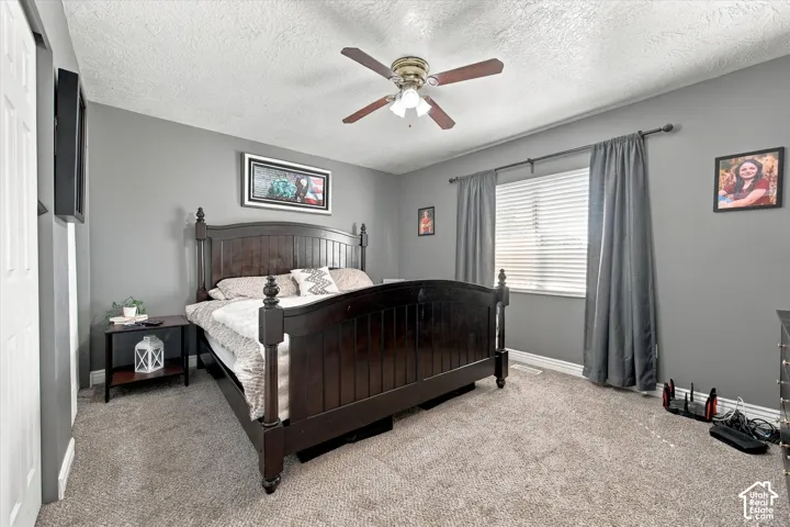 Carpeted flooring, window with blinds, ceiling fan with integrated lighting, and painted walls