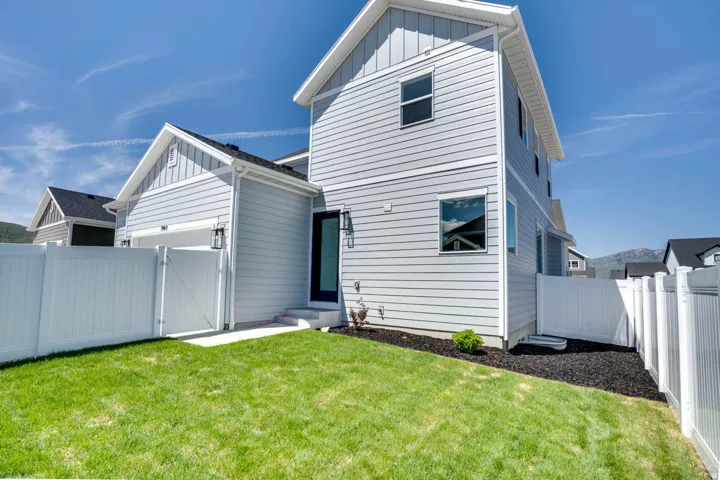 Expansive lawn area, full privacy fencing, and exterior wall lanterns