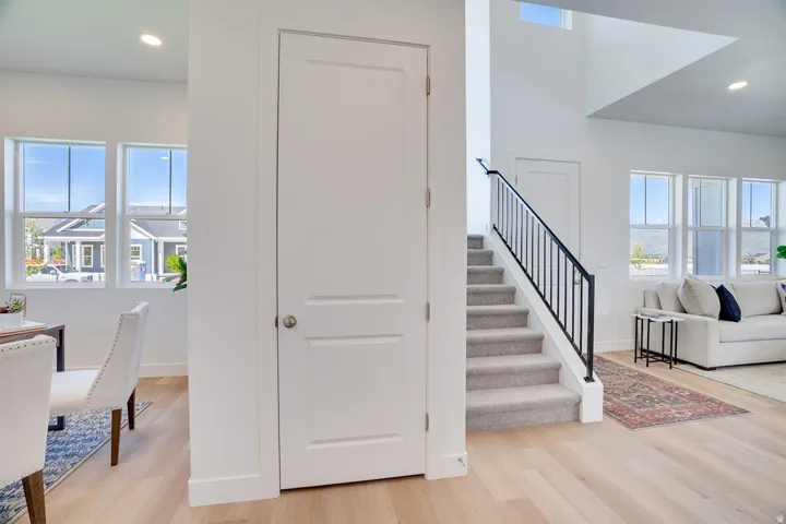 Open-concept living space with light wood-finish flooring, recessed lighting, and ample natural light from multiple windows