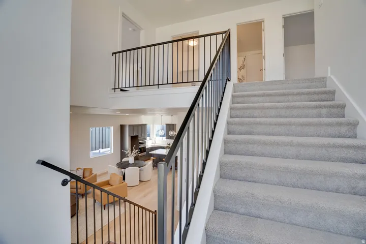 Carpeted staircase with black metal railings