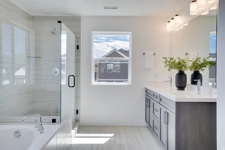 Dual vanity with stone-finish countertop, wood-finish cabinetry, and chrome fixtures