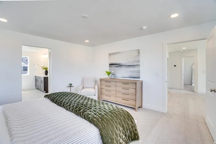 Recessed lighting, light-toned carpeting, and white walls