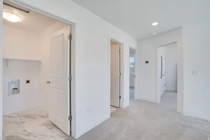 Laundry area with tiled flooring, utility hookups, and a built-in shelf