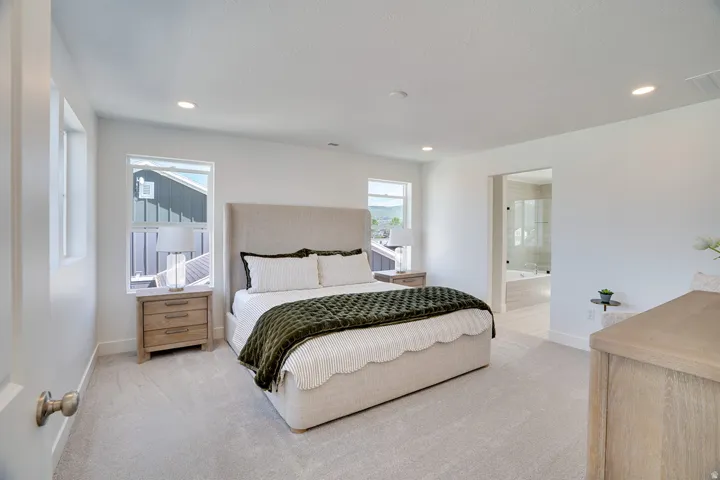 Recessed lighting, light-toned carpeting, and multiple windows