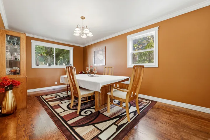 Wood-finish flooring with crown molding and white trim