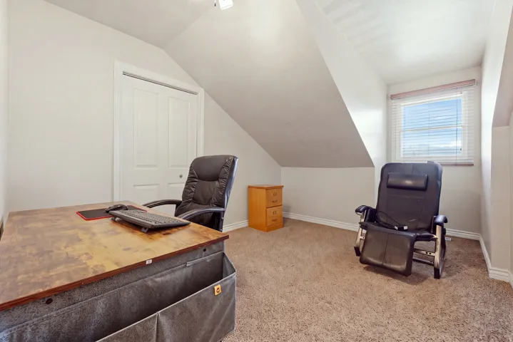 Carpeted room with a window, white trim, and a built-in closet with bifold doors