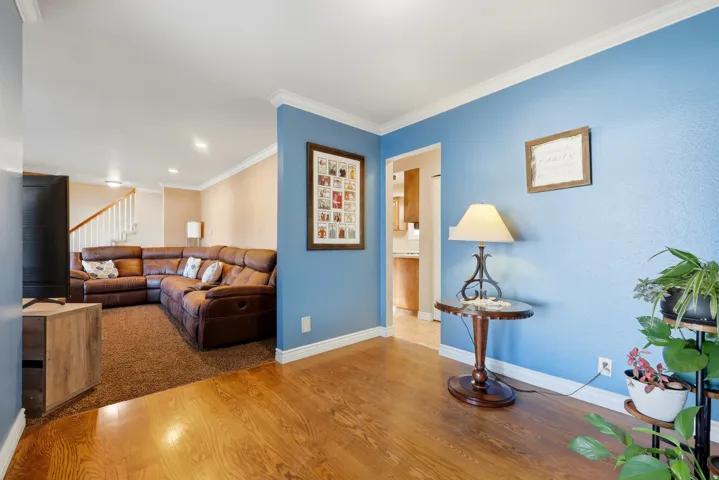 Hardwood-finish flooring, crown molding, and white baseboards