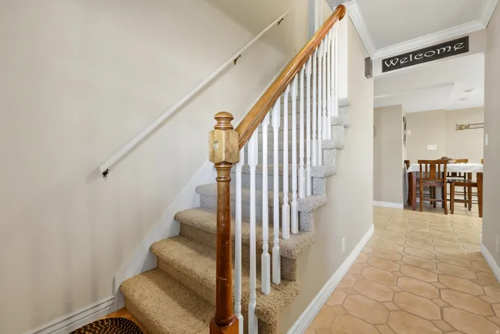 Carpeted staircase with wood newel post and handrail
