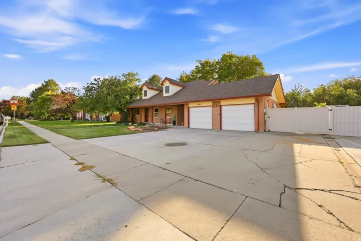 Brick exterior with white garage doors, dormer windows, and a fenced side yard